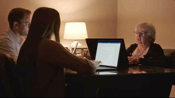 A male and female law student interview with a woman at a table.