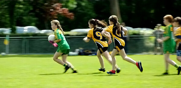 Eva Martin is playing on the Gaelic football field.