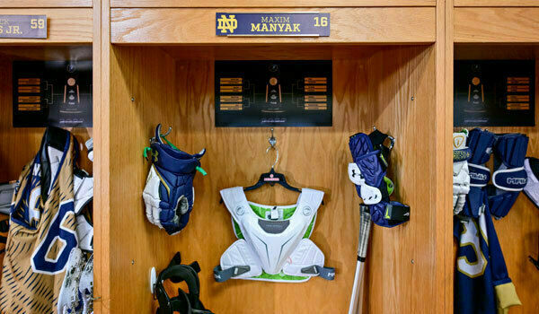 A male and female in lab coats looking at capped test tubes.