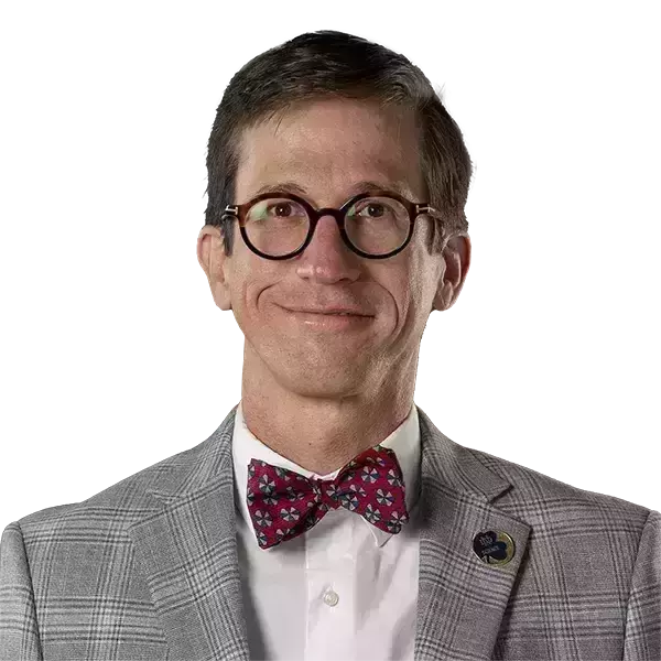 Bust of Santiago Schnell wearing a gray suit and red bow tie.