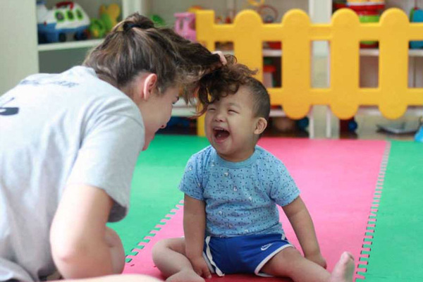 A newborn NICU baby laying on it's stomach wearing a knit cap.