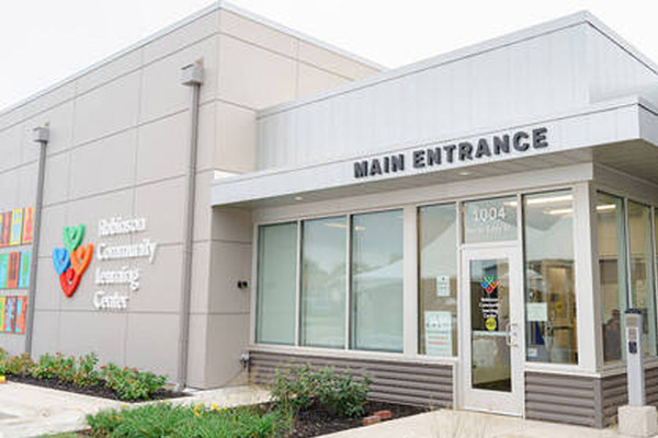 A newborn NICU baby laying on it's stomach wearing a knit cap.