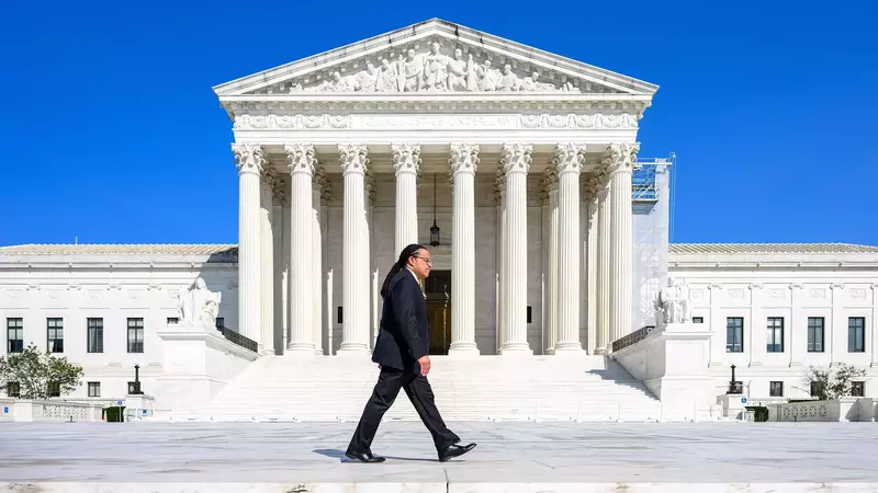 Marcus Cole walks across the steps of the Supreme Court in Washington DC.