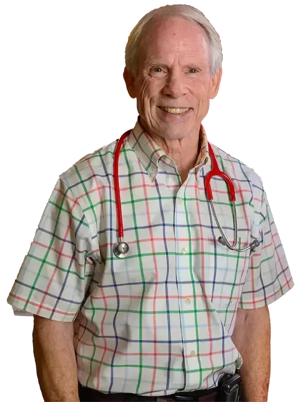 A smiling, older man with short white hair wears a short-sleeved, plaid shirt with thin red, green, and blue stripes on a white background. He has a red stethoscope around his neck.