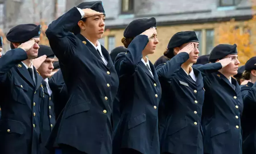 Several individuals in U.S. Army dress uniforms salute with their right hands touching their berets.