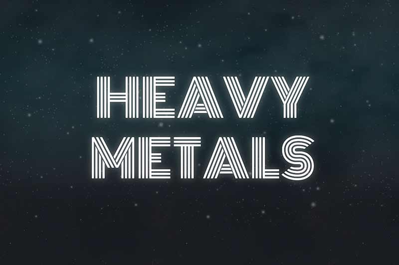 The words &lsquo;HEAVY METALS&rsquo; in a striped, neon font against a dark, starry background. 
