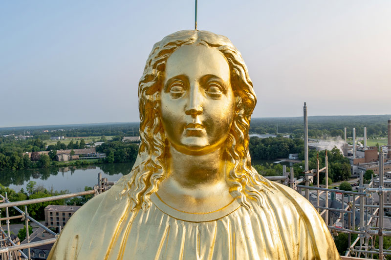 A close up view of Mary's face on the statue on top of the Golden Dome.