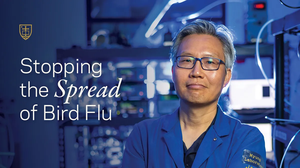 Three people, two men and a woman, stand talking in an industrial warehouse aisle filled with tall metal shelving and boxes of eggs.
