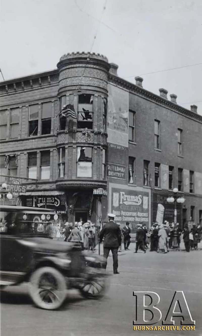 Movie poster for 'The Birth of a Nation' depicts a klansman holding a fiery cross while riding a robed horse. 