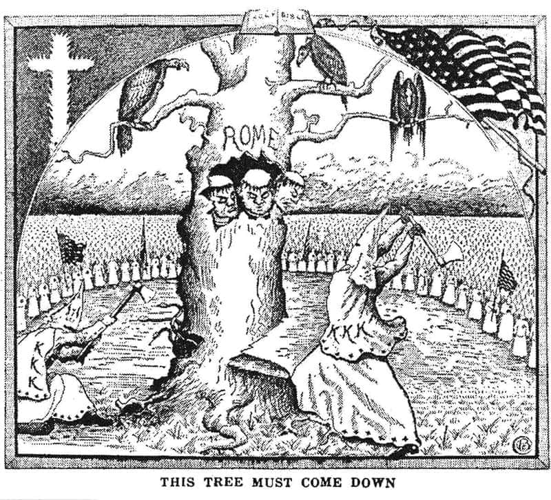 Two Klansmen with axes hack at a tree labeled 'Rome'. Inside a hole in the tree, threes heads of monks pop out and snakes slither out the bottom. Vultures sit on the branches of the tree. A crowd of Klansmen encompass the tree. A fiery cross is in the upper left corner, an American flag is in the upper right corner, and an open bible is in the top center.