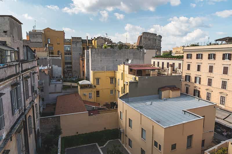 Building rooftops and the Colosseum in the background in Rome, Italy.