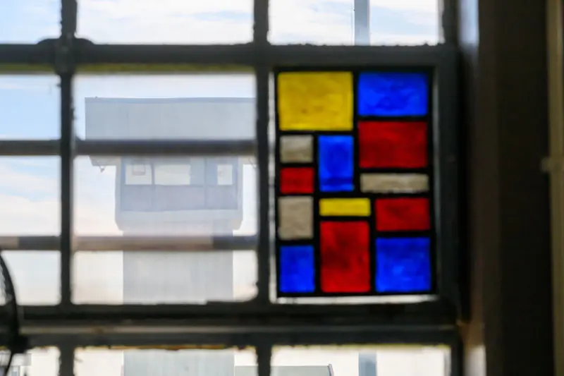 A view of the prison tower through a brightly colored stained glass window.