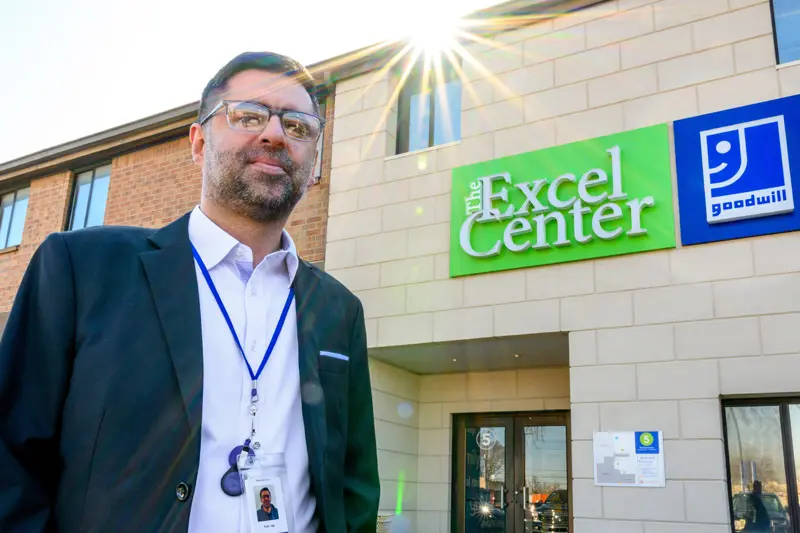 Rizan Hajji Mohamed stands in front of The Excel Center building in Indianapolis.