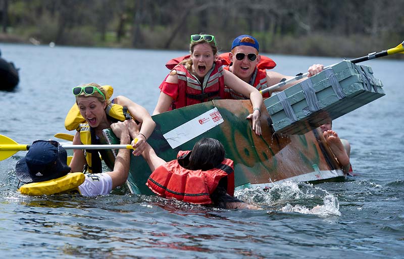 Students fall from a raft into the water.