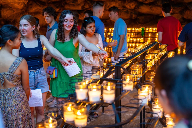 Students light votive candles in the Grotto at the University of Notre Dame.