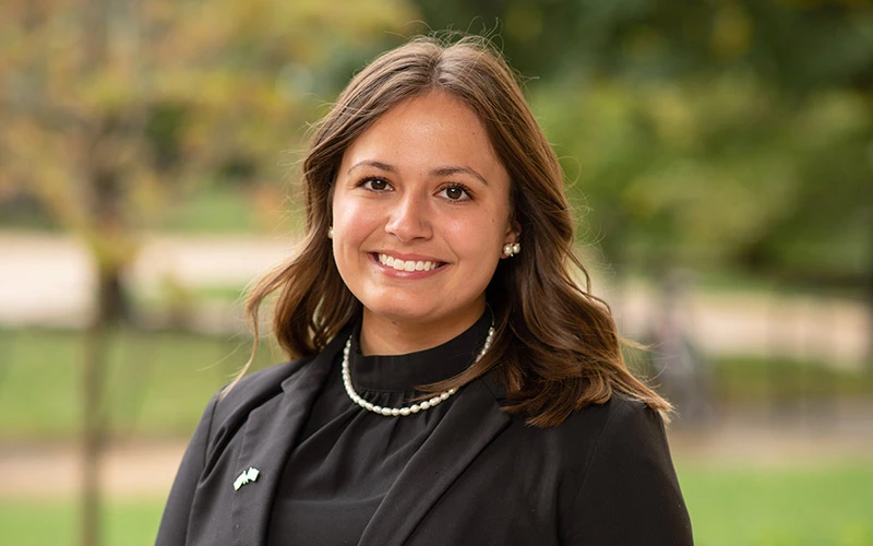 A young, brown-haired woman in a black top.