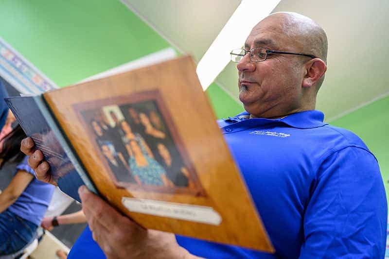 A man looks at a book of his family's history.