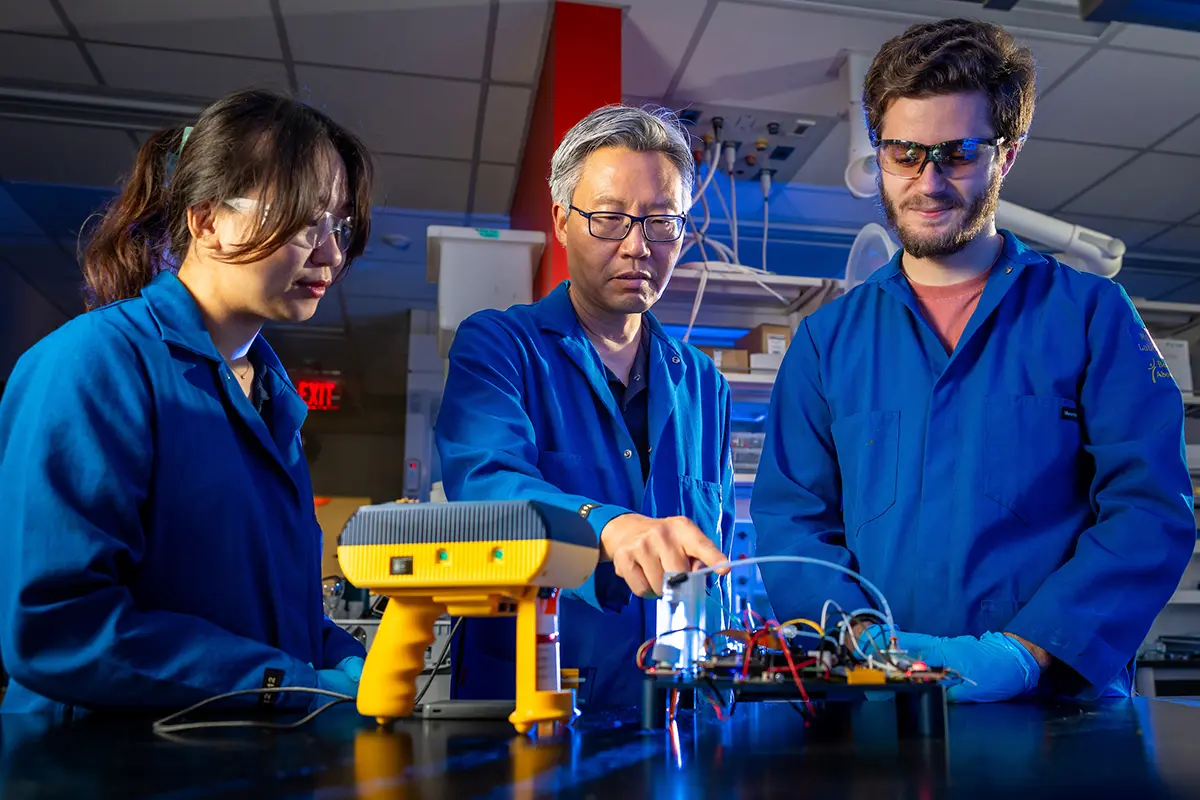 Nosang Myung discussing with Notre Dame graduate students how the 'sniffing' technology works.