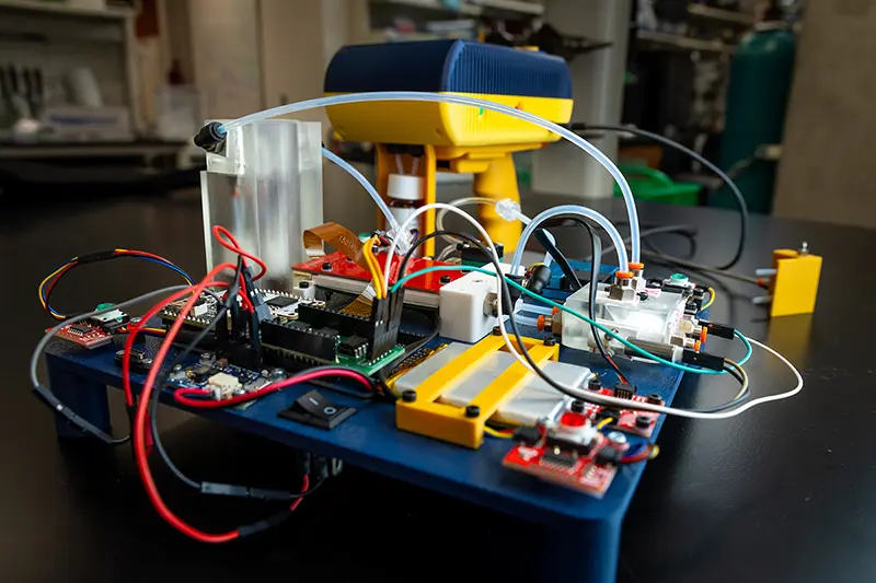 The 'sniffer' device sits behind a prototype board used in the development stages.