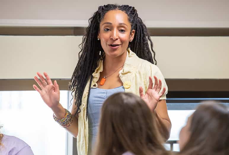 A woman speaks in front of students.