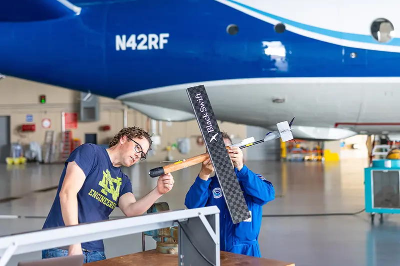 David Richter and Joe Cione inspect a drone before takeoff in a hangar in Florida.