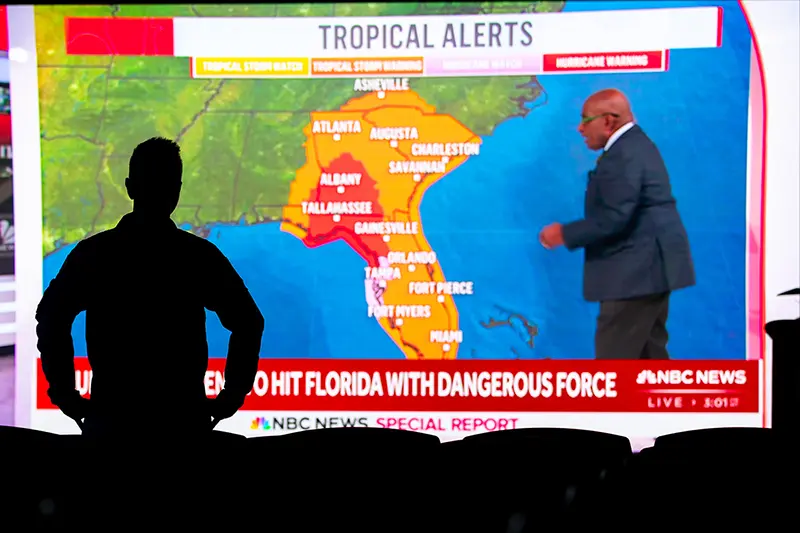Joseph Cione stands in front of a large projector screen with NBC News weather presentation on Hurricane Helene that was making landfall in Florida.