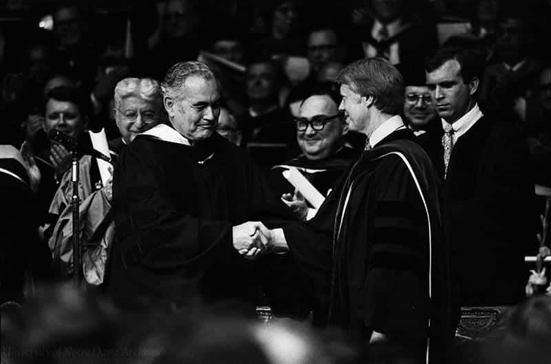 Jimmy Carter shakes Father Hesburgh's hand on the commencement stage.