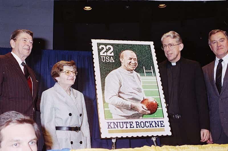Ronald and Nancy Reagan pose with Monk Malloy and a poster-size version of the new Knute Rockne stamp.