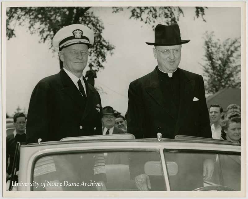University President Rev. J. Hugh O'Donnell and Fleet Admiral Chester W. Nimitz standing up in a convertible car, 1946.