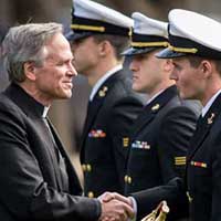 University president Rev. John I. Jenkins, C.S.C. presents an award to a Naval Midshipman during the 2016 ROTC Presidential Pass in Review. April, 2016.