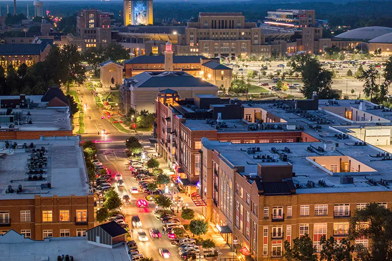 Eddy Street at dusk, shot from above with the Hesburgh Library and the Word of Life Mural—more commonly known as Touchdown Jesus—lit up in the background.