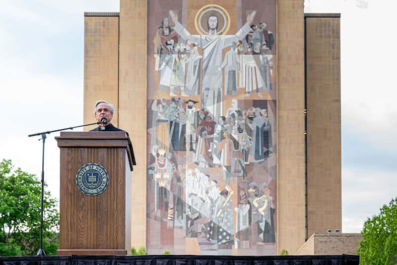 Father John stands at a podium.