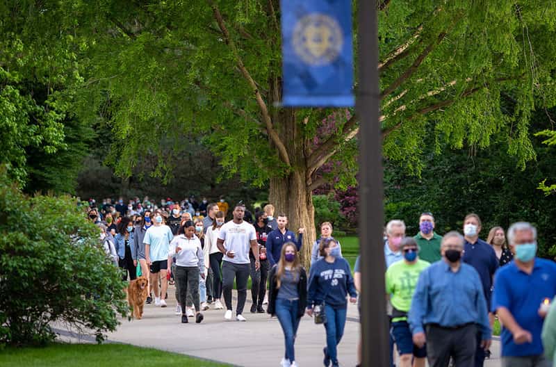 A group of people wearing masks march together.