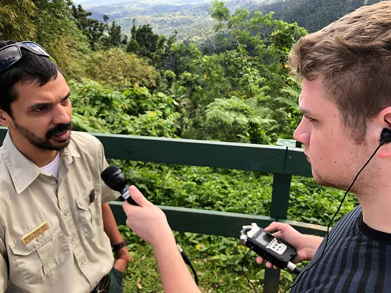 A student interviews a man at the El Yunque National Forest.