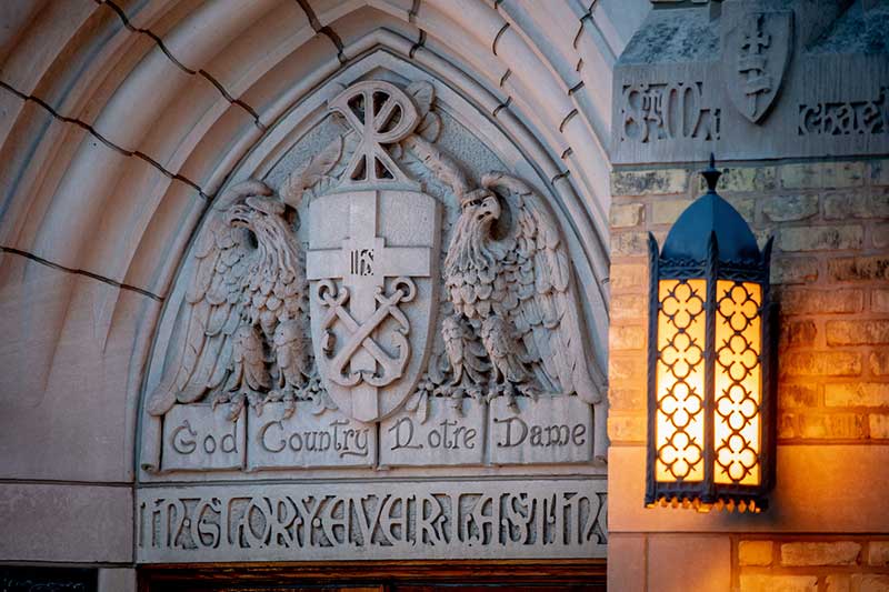 Basilica of the Sacred Heart exterior World War I Memorial door. Ttwo strong eagles supporting a shield bearing the university seal and it is surmounted by the Chi and Rho of Christ&rsquo;s monogram: The eagles carry in their claws a ribbon which reads 'God, Country, Notre Dame.'