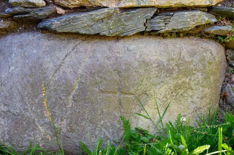 A close up of a cross carved into a stone.