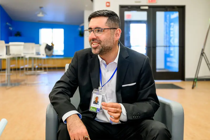 Rizan Hajji Mohamed shows off his employee badge.