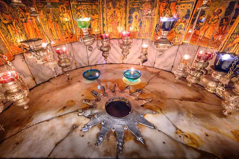A close up shot of a colorful shrine with brightly lit candles.