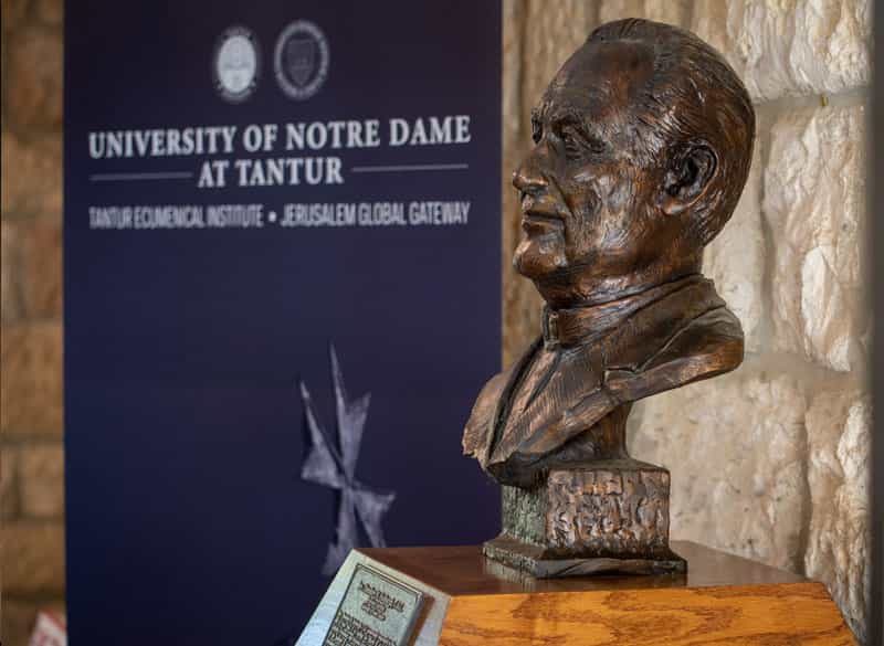 Rev. Theodore Hesburgh, C.S.C. bust statue with a Notre Dame at Tantur banner in the background.