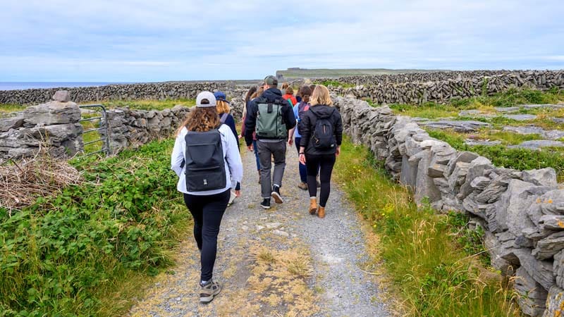 Students walk along stone walls.