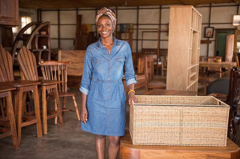 Evelyn Zalwango stands next to a basket that made out of banana fibers.