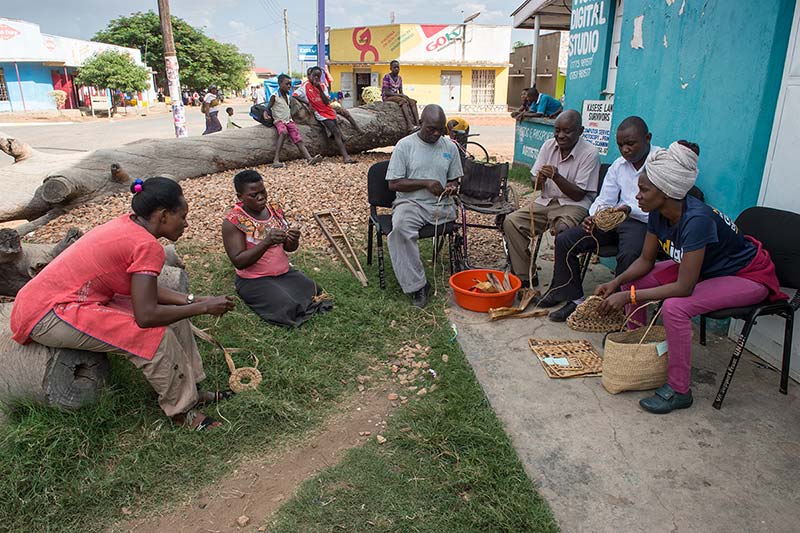 A group of victims making rope with banana fibers.