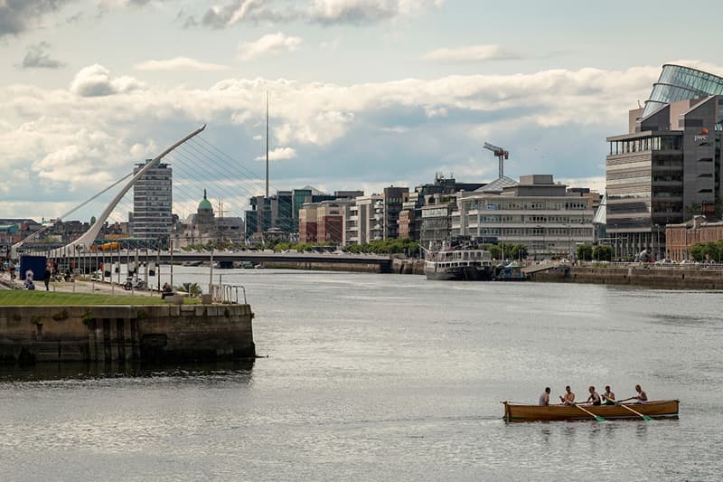 Rowers on River Liffey with the Samuel Beckett Bridge in the background in Dublin, Ireland.