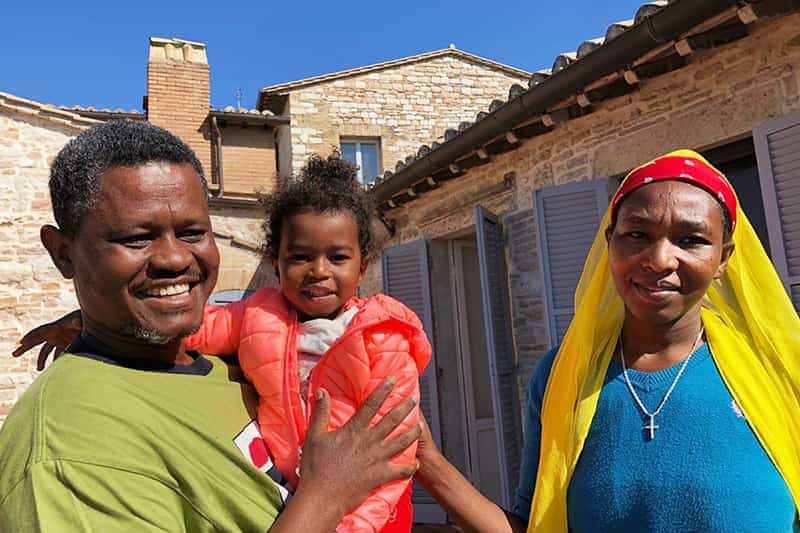 An African refugee family hug and smile for the camera.