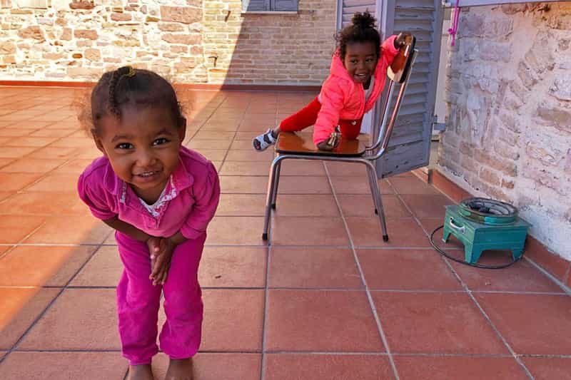 Two young girls dressed in pink smile for the camera.
