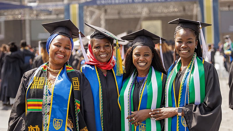 Four Nigerian women standing in their graduation attire after the Notre Dame commencement ceremonies.